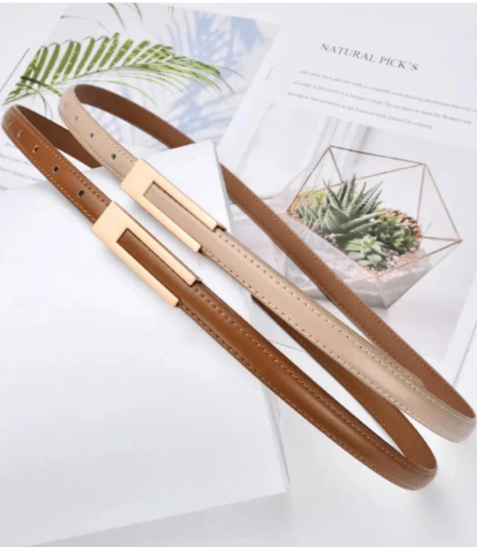 Women's skinny belt in caramel vegan leather styled with a desk setup