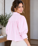 Back view of light pink puff sleeve blouse with gathered yoke and buttoned cuffs