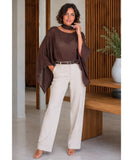 Dark brown sheer cape top styled with ivory wide-leg trousers, full-length view