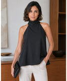 Black high neck halter top styled with ivory trousers and a clutch