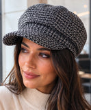 Close-up view of the black houndstooth tweed newsboy cap's weave