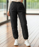 Woman wearing black quilted joggers with ribbed cuffs
