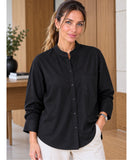 Women's relaxed black button up shirt with a mandarin collar, rolled sleeves and ivory trousers