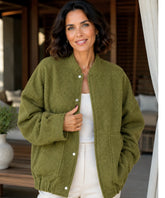 Woman wearing an oversized boucle bomber jacket in olive green