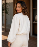 Woman wearing a cropped wool bomber jacket in beige