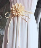 Women's ivory flower belt with long tie ends styled on a white dress
