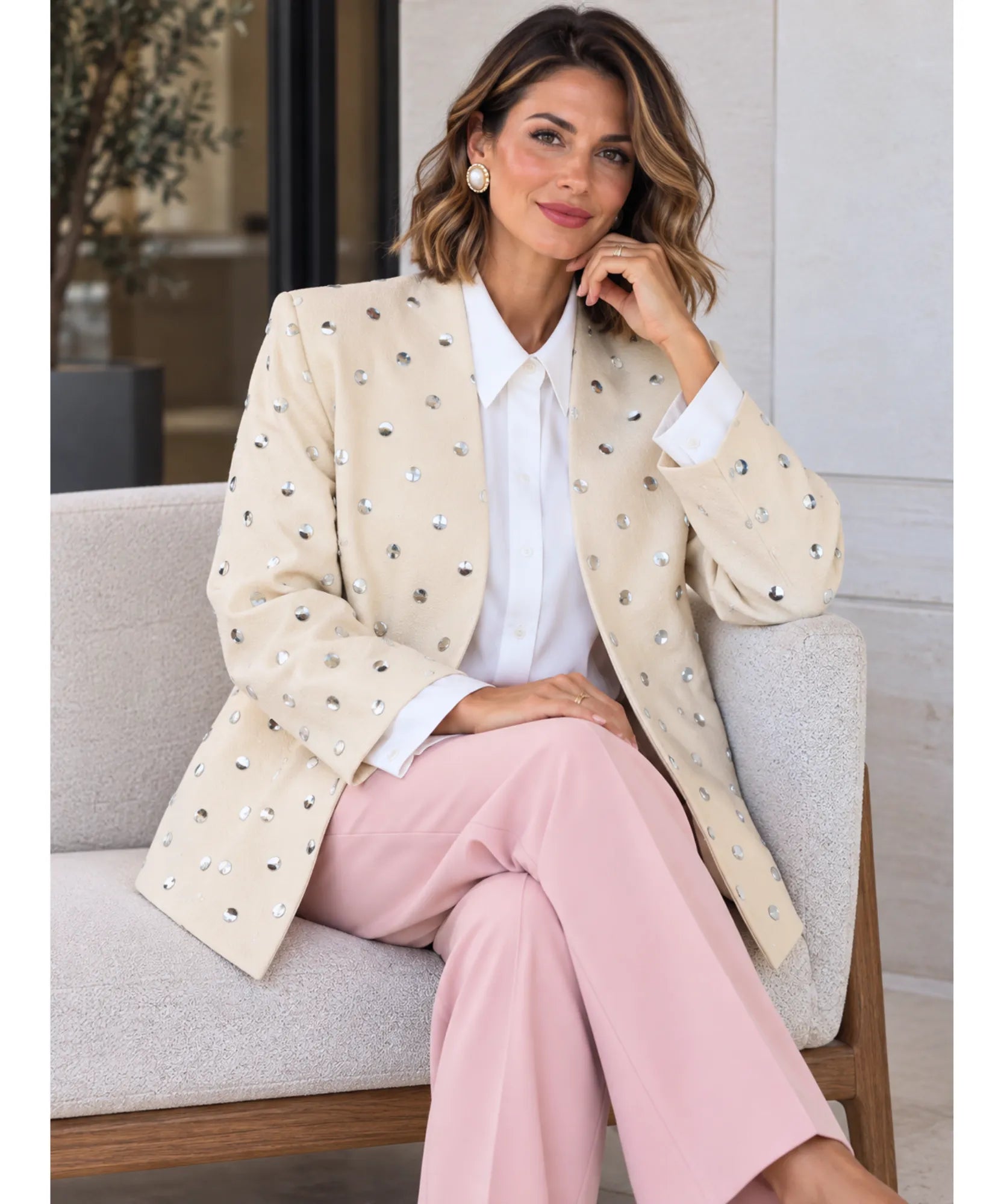 Beige oversized blazer with pink pants, seated pose