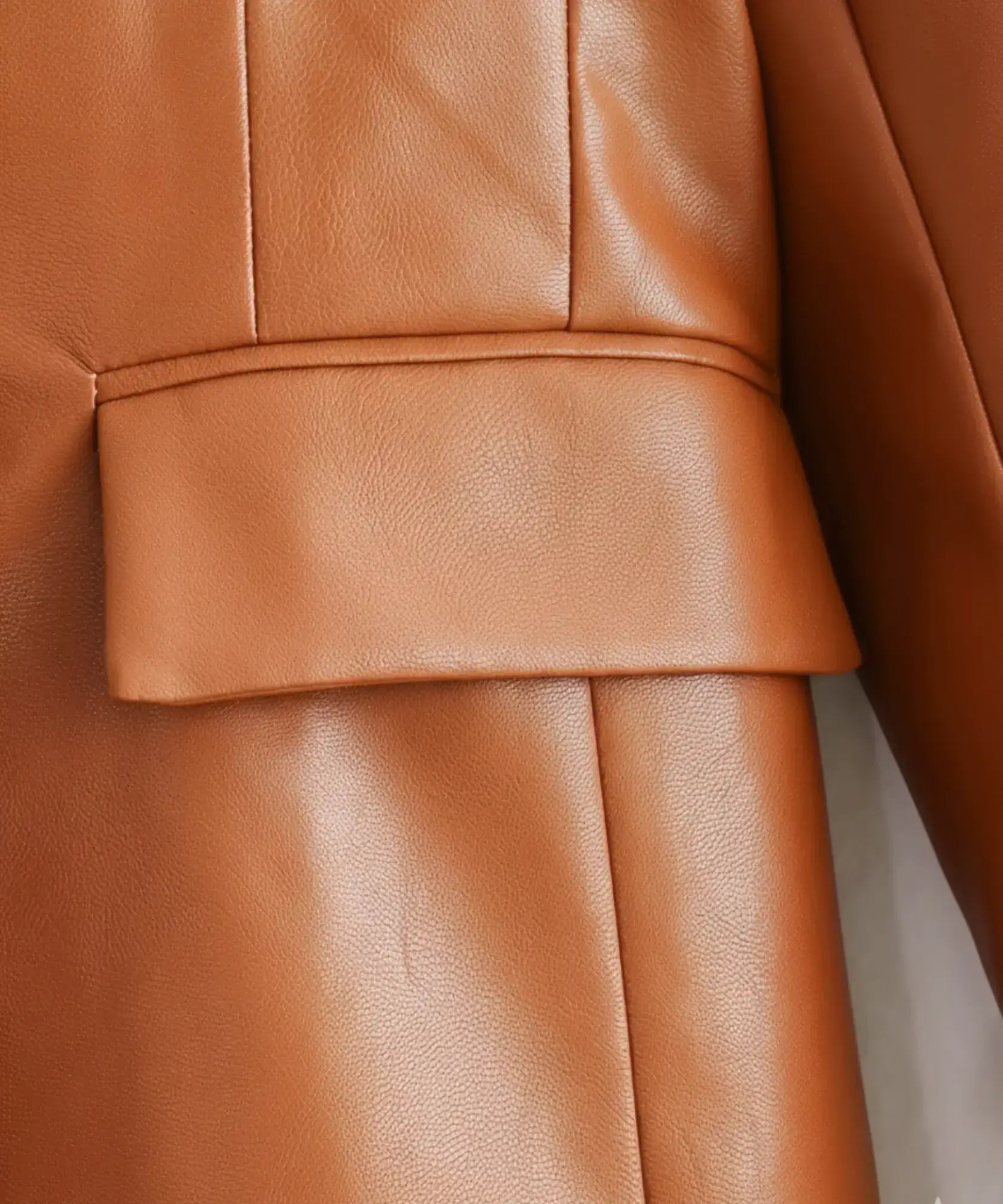 Women's leather blazer with gold buttons, flat lay