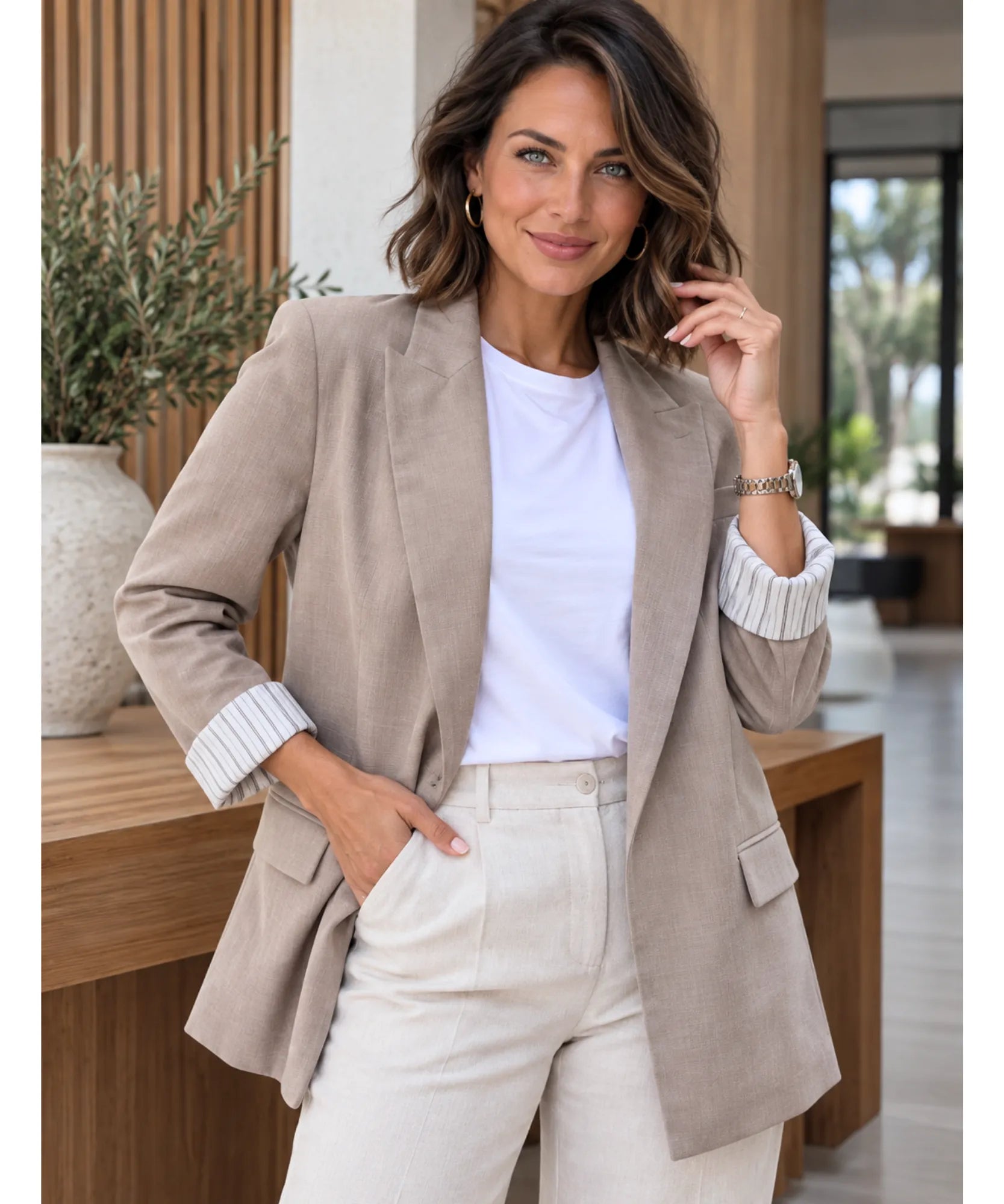 Women's taupe linen blend blazer with striped cuffs styled with a white top and cream trousers