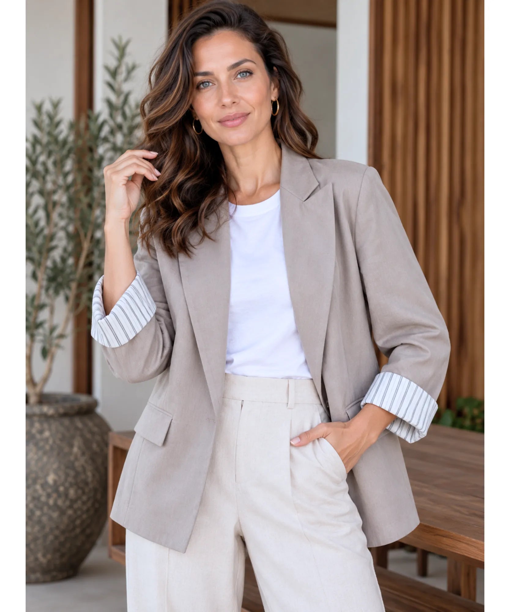 Woman smiling in a taupe linen blend blazer with striped cuffs