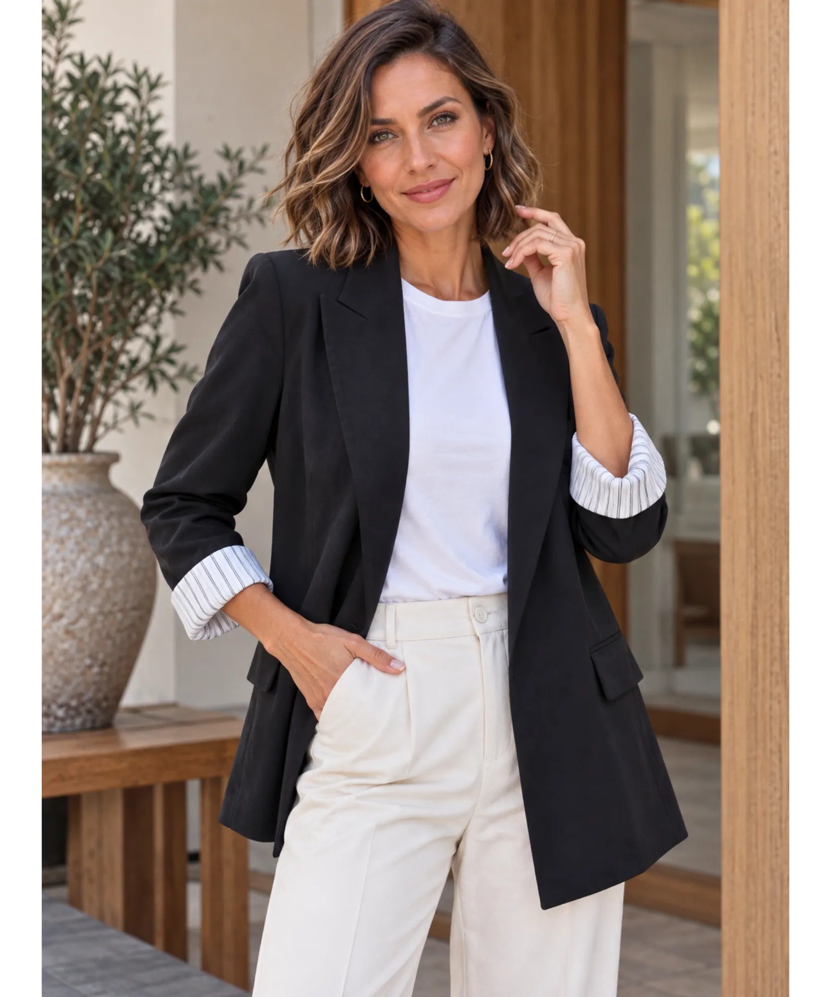 Women's black linen blend blazer with inset side pockets styled with cream trousers