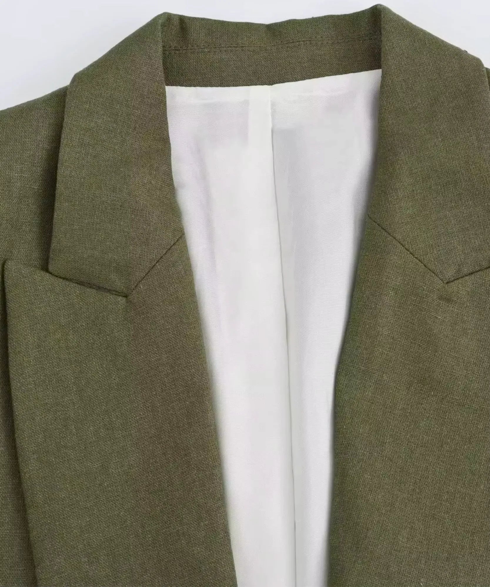 Close up of the notch lapel and lining on an olive green linen blend blazer
