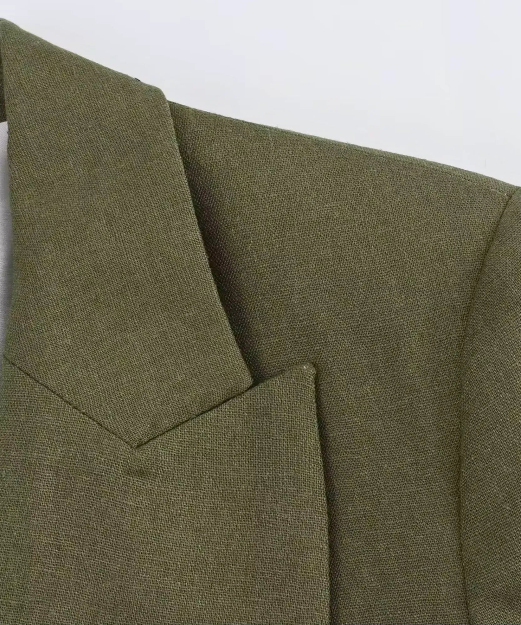 Close up of the linen blend fabric texture on an olive green blazer