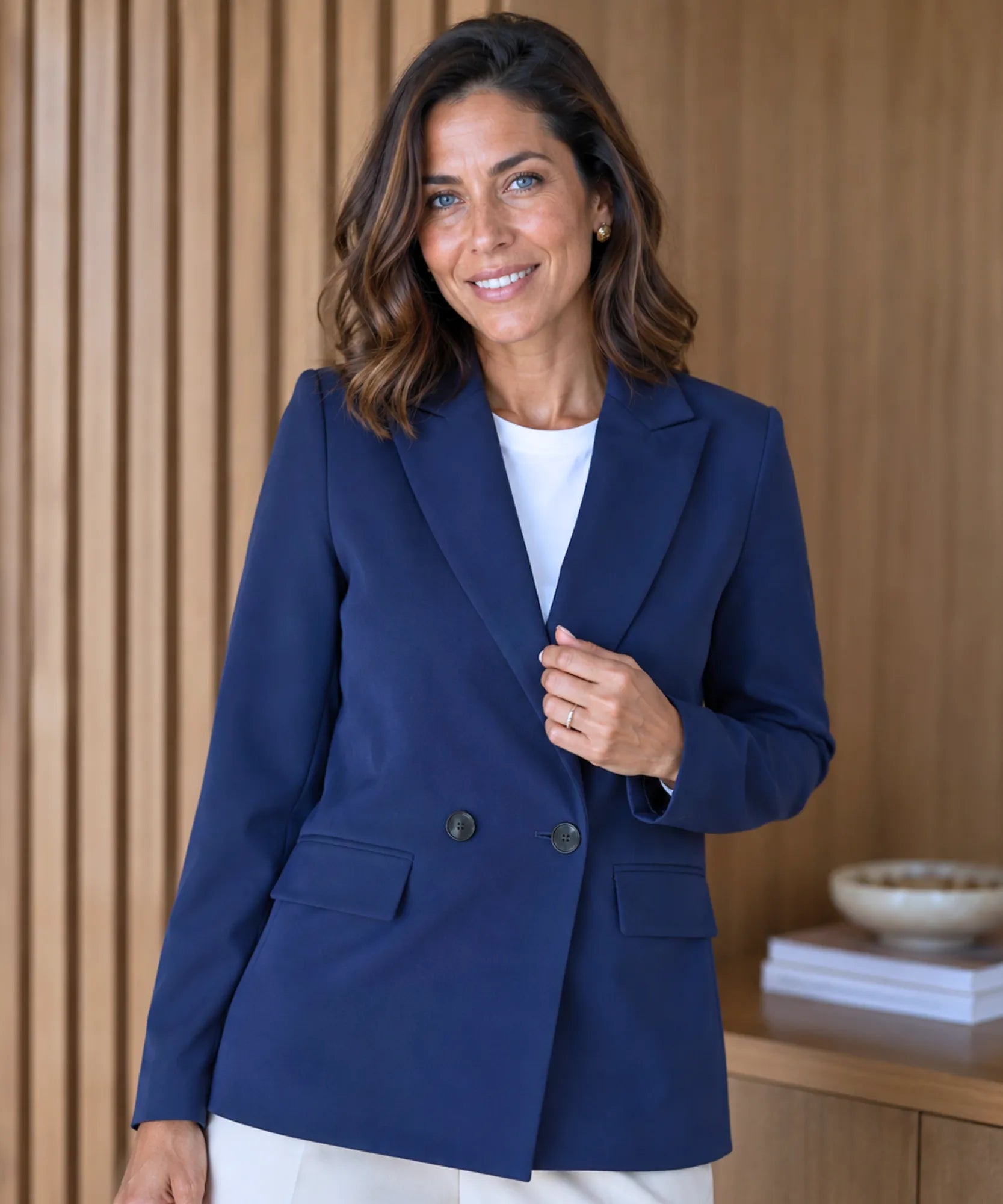 Women's navy double breasted blazer with front buttons, three quarter pose