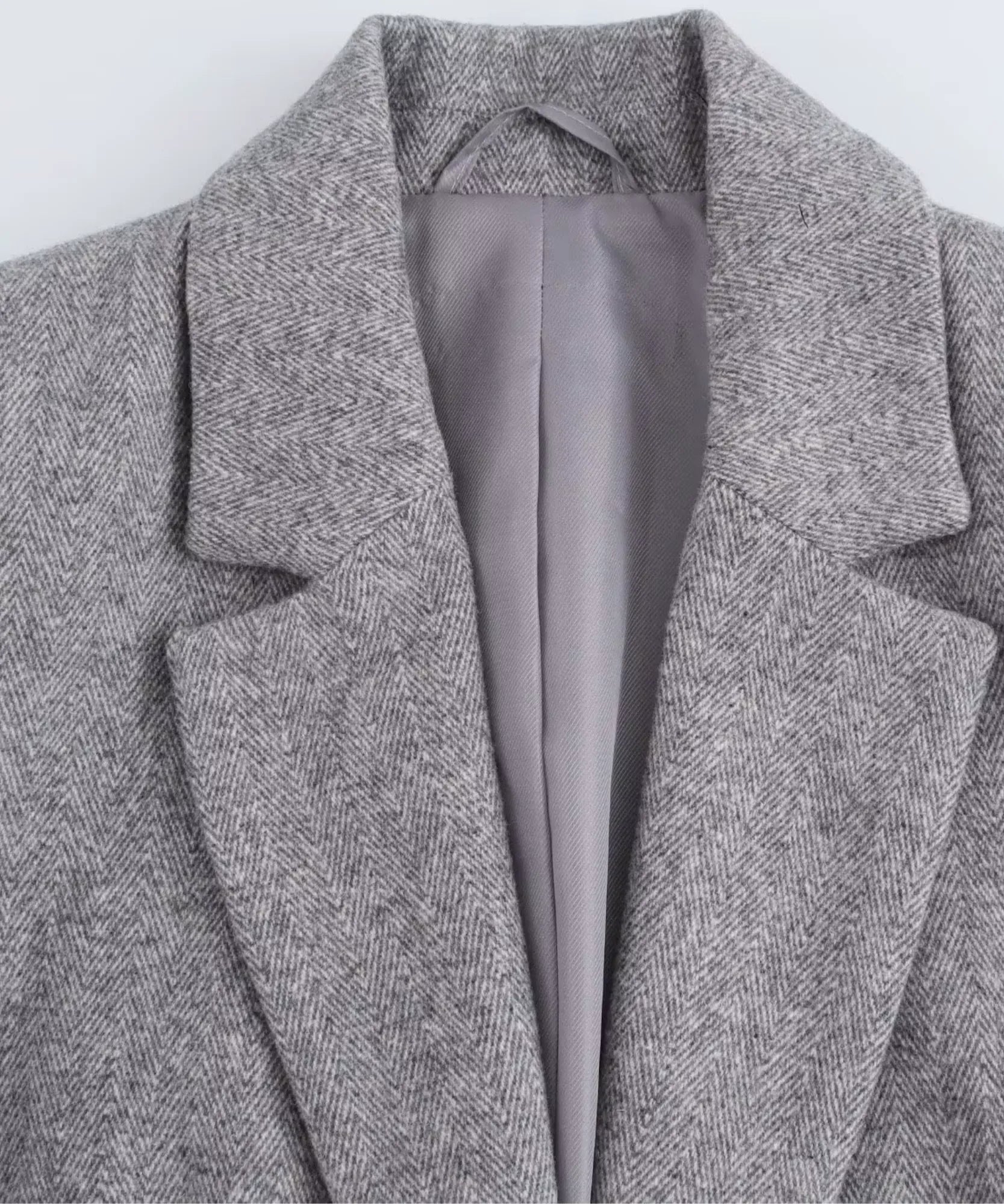 Close up of the notch lapel and satin lining of the grey blazer