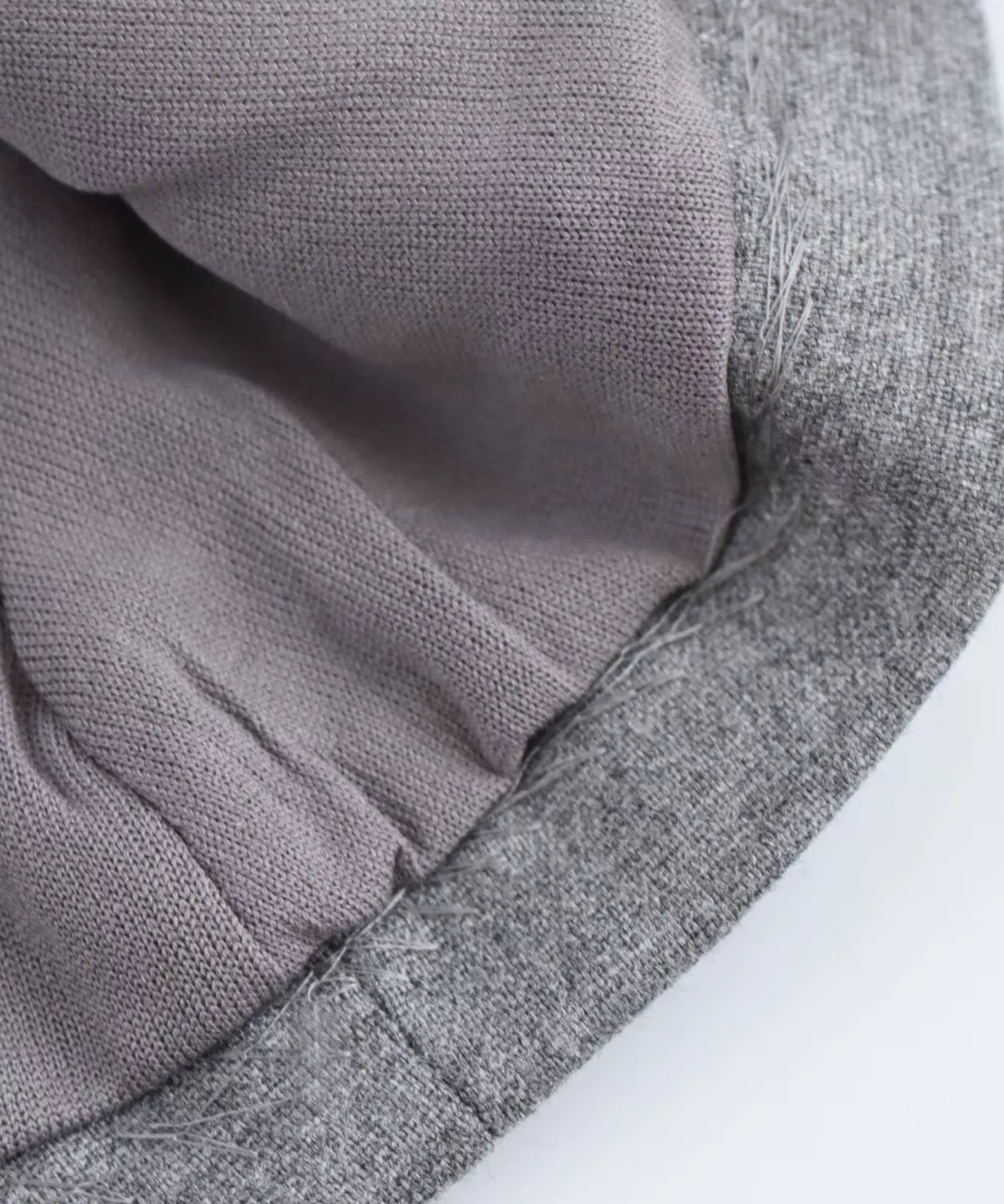 Detail of the lining and hem finish on a heather gray peplum top