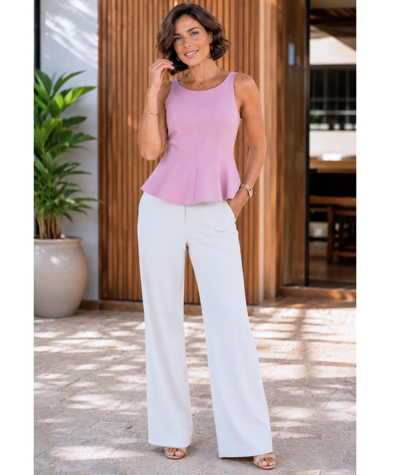 Orchid pink tie back peplum top styled with white wide-leg trousers, full length