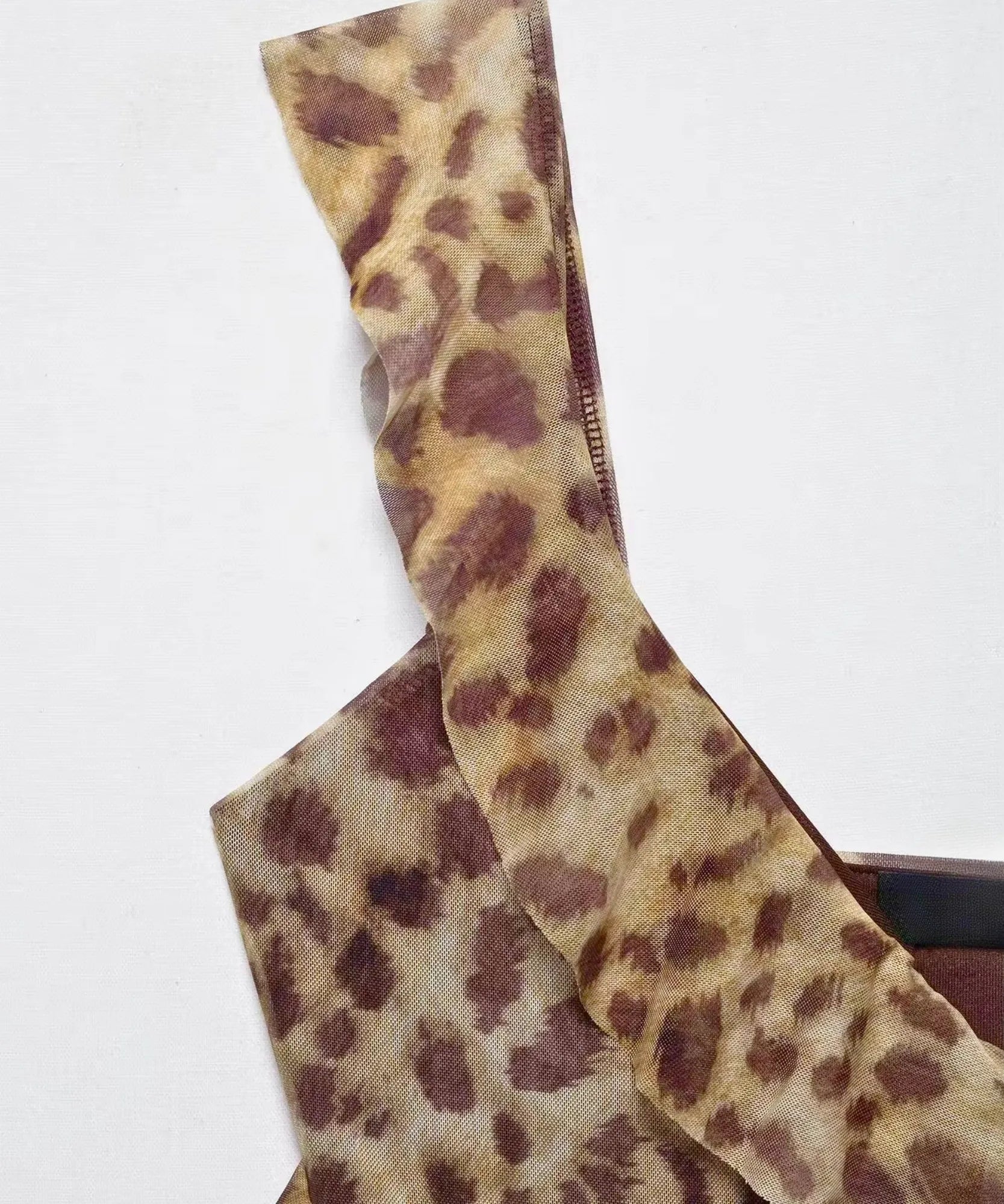 Flat lay detail of leopard print ruffle along the neckline