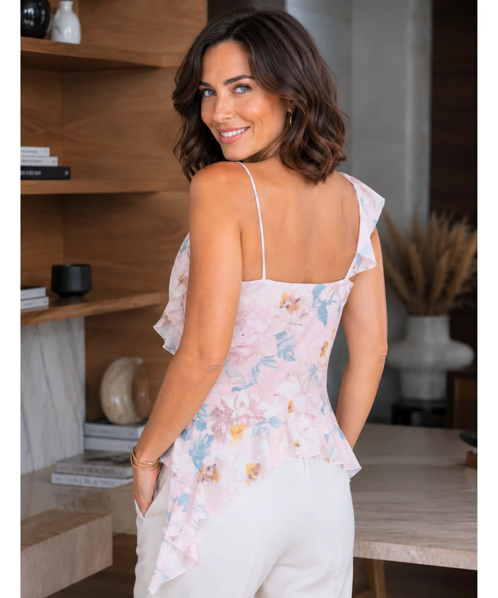 Back view of a blush floral ruffle top with thin straps