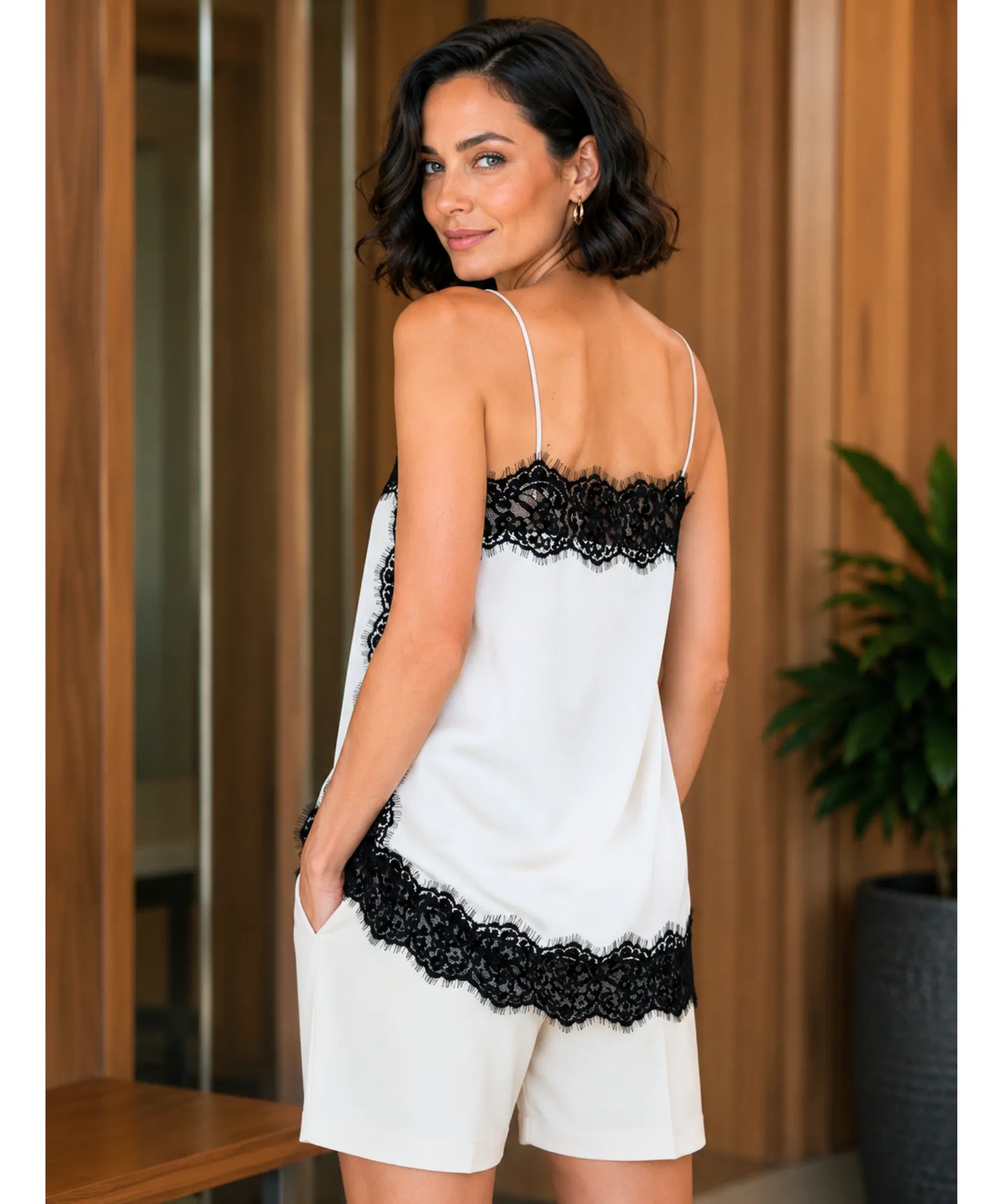 Back view of ivory satin cami top with black lace trim styled with white shorts