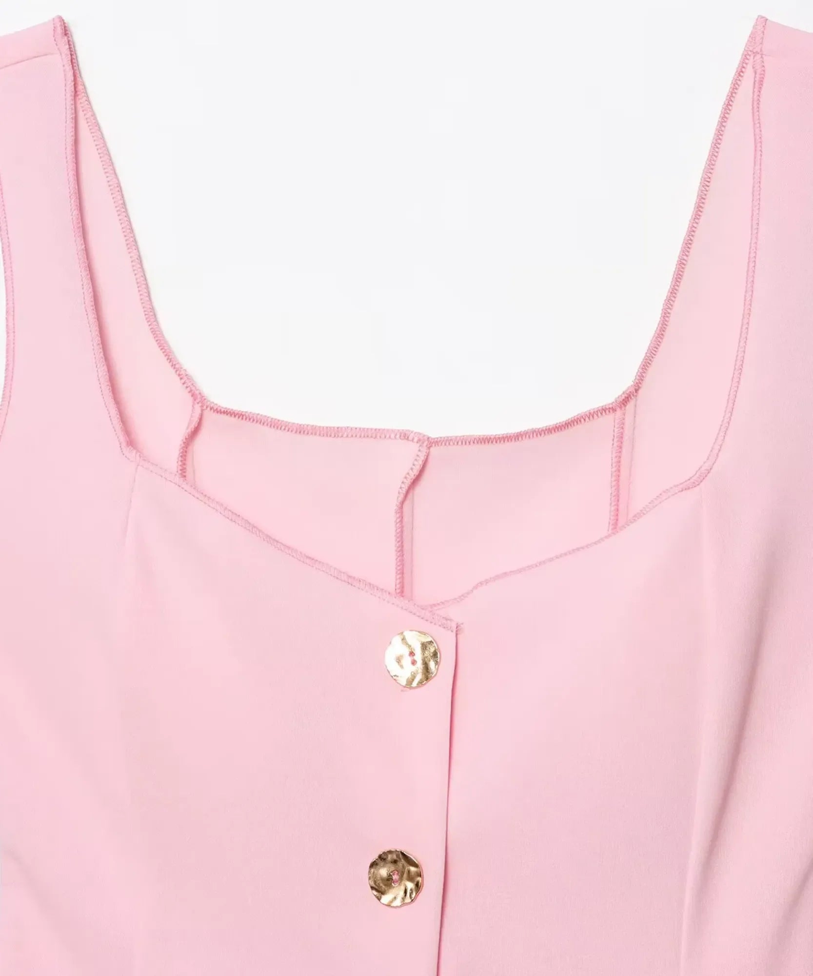 Detail of the square neckline and gold buttons on a light pink peplum tank top