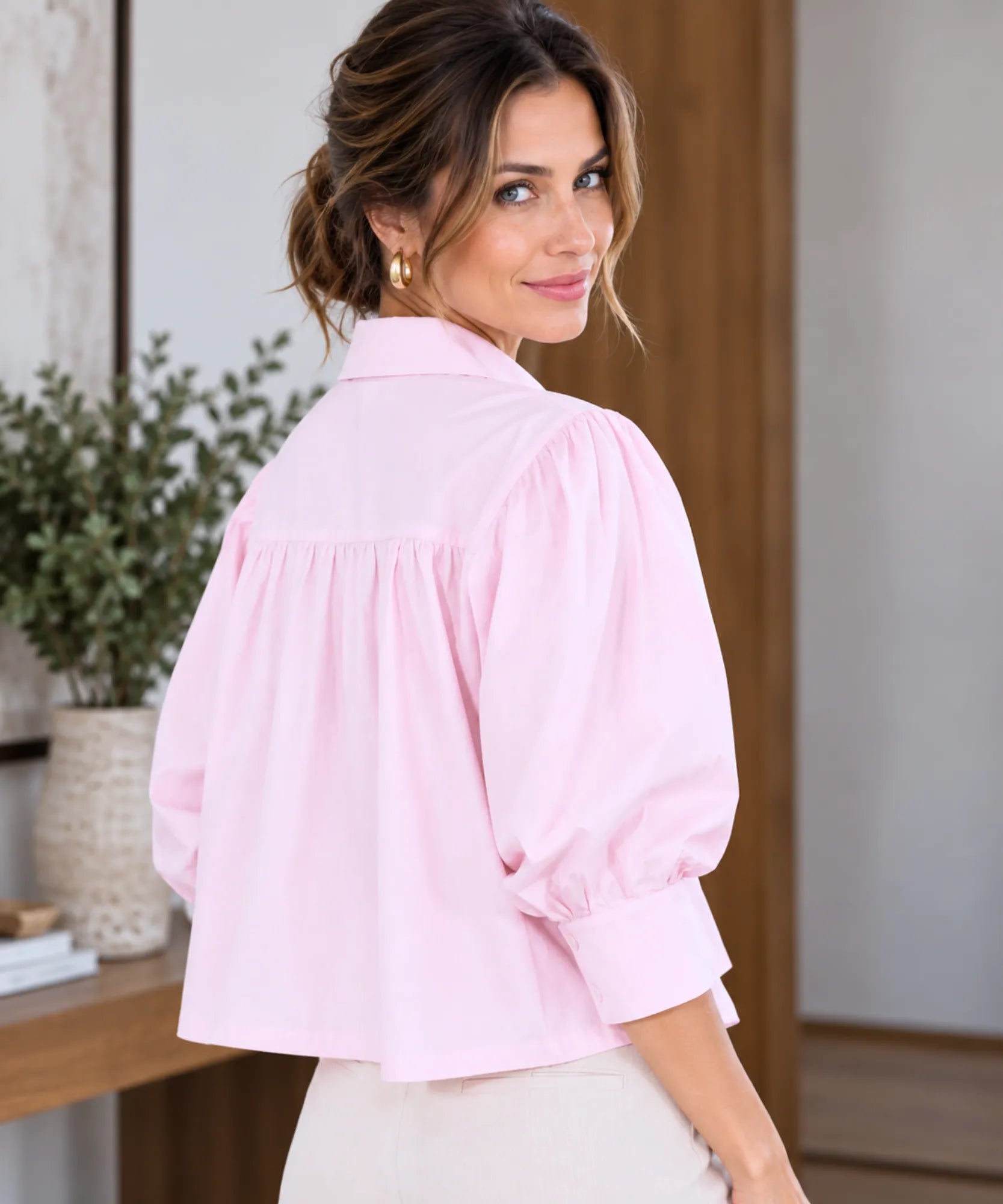 Back view of light pink puff sleeve blouse with gathered yoke and buttoned cuffs