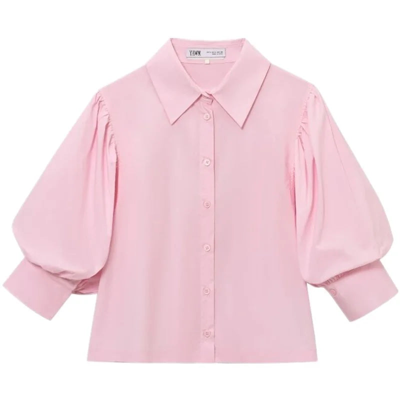 Flat lay of light pink puff sleeve blouse with collar and button placket