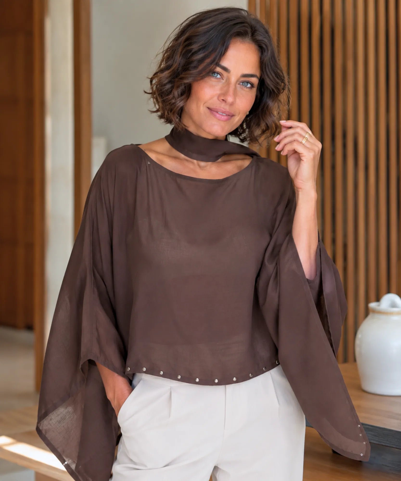 Dark brown sheer cape top with scarf collar and studded hem, front view