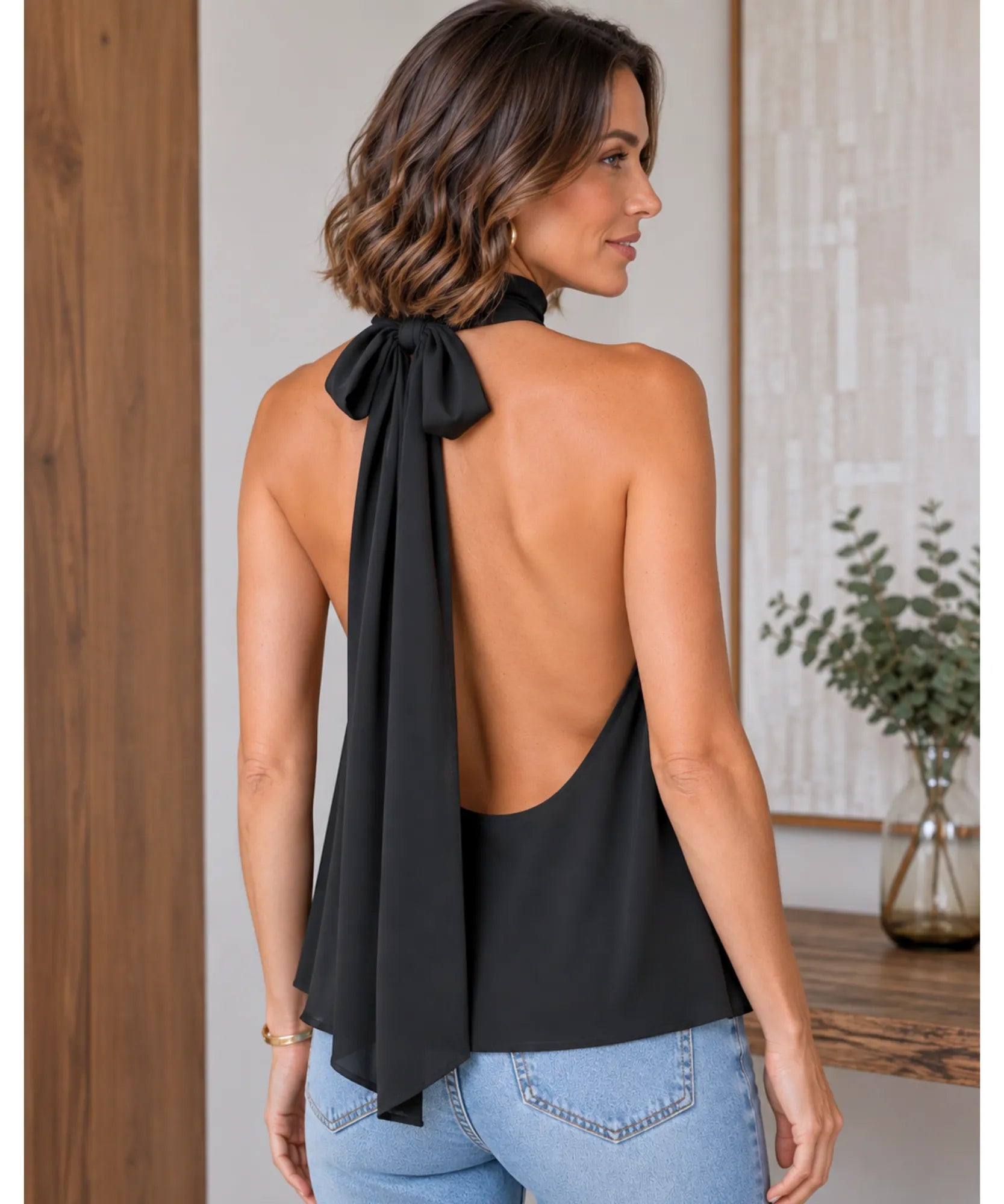 Back view of a black halter top with open back and tie neck
