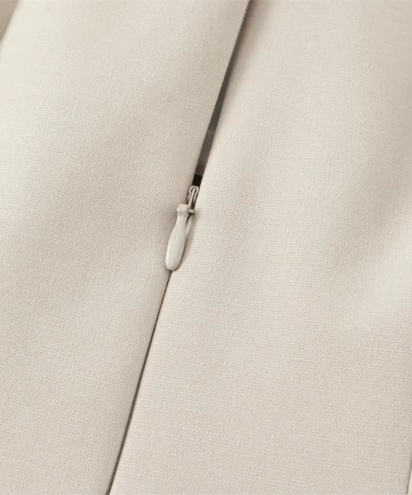 Center front zip and pull detail on ivory tailored crepe