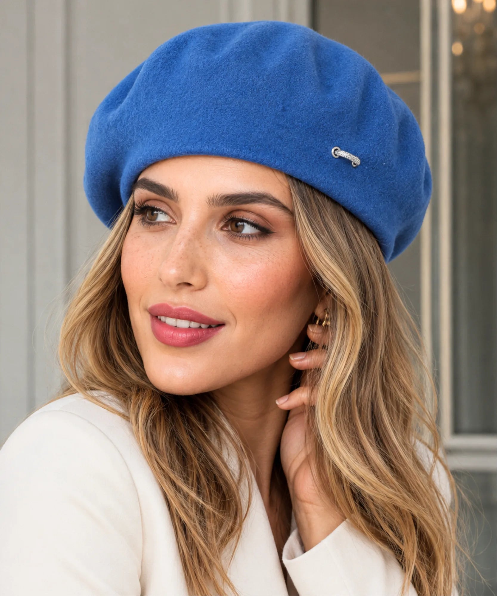 Close-up of a blue wool-blend French beret with its metal brooch detail