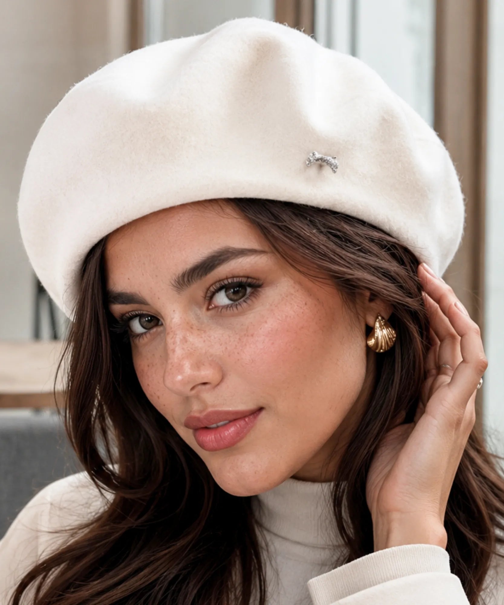 Woman wearing an ivory wool-blend French beret styled with a coat