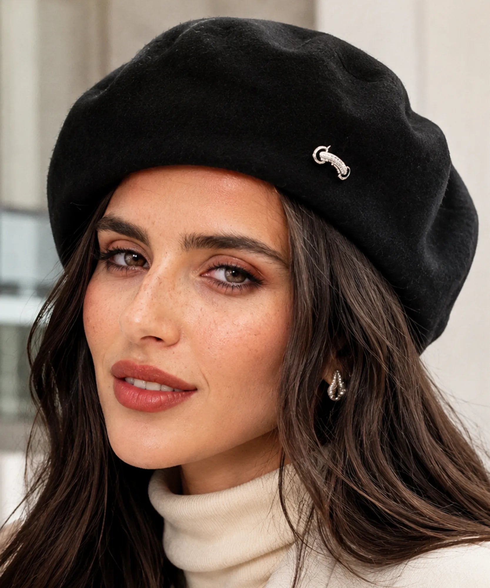 Woman wearing a black wool-blend French beret with a metal brooch