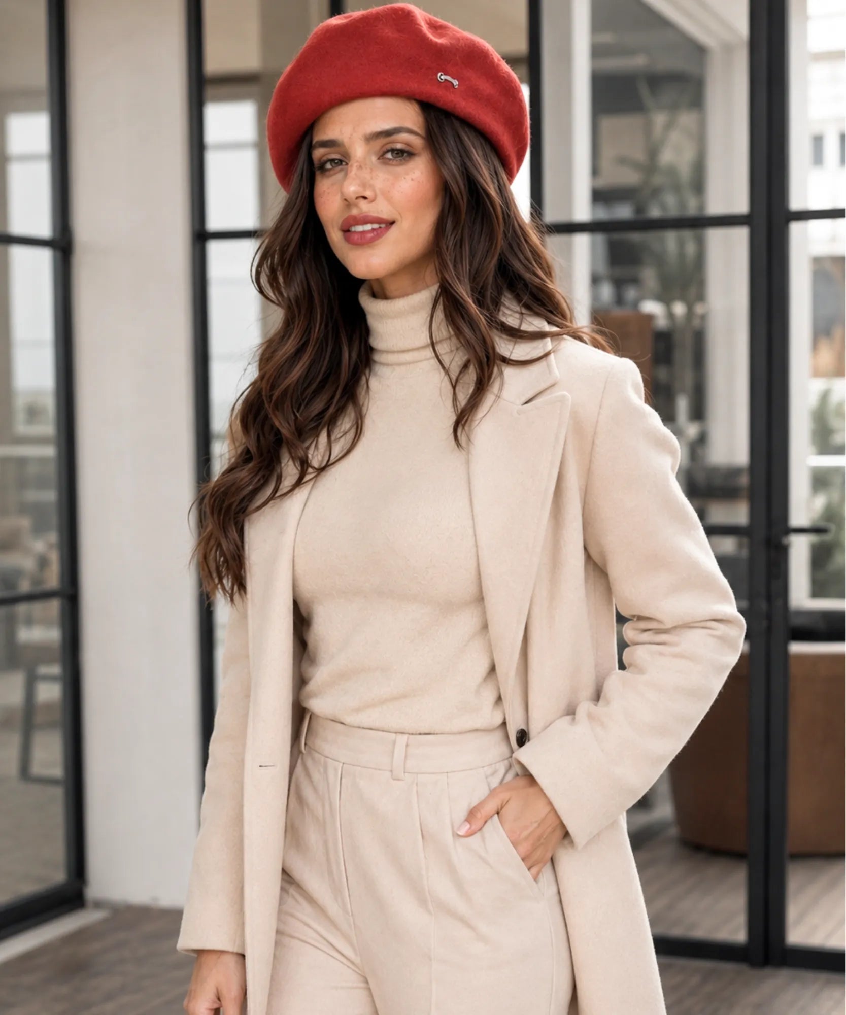 Close-up of a red wool-blend French beret with its metal brooch detail
