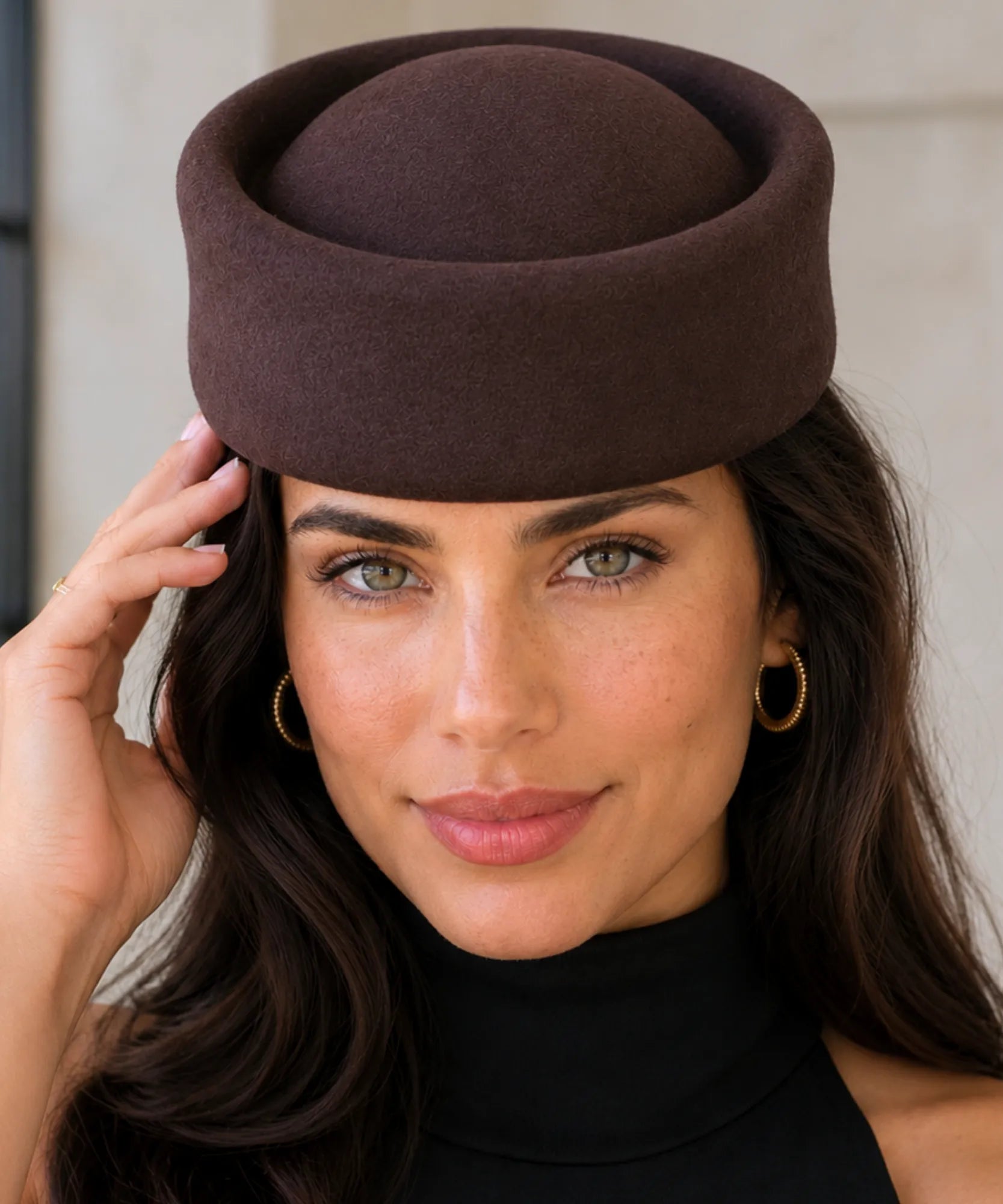 Dark brown wool pillbox hat shown against a plain background