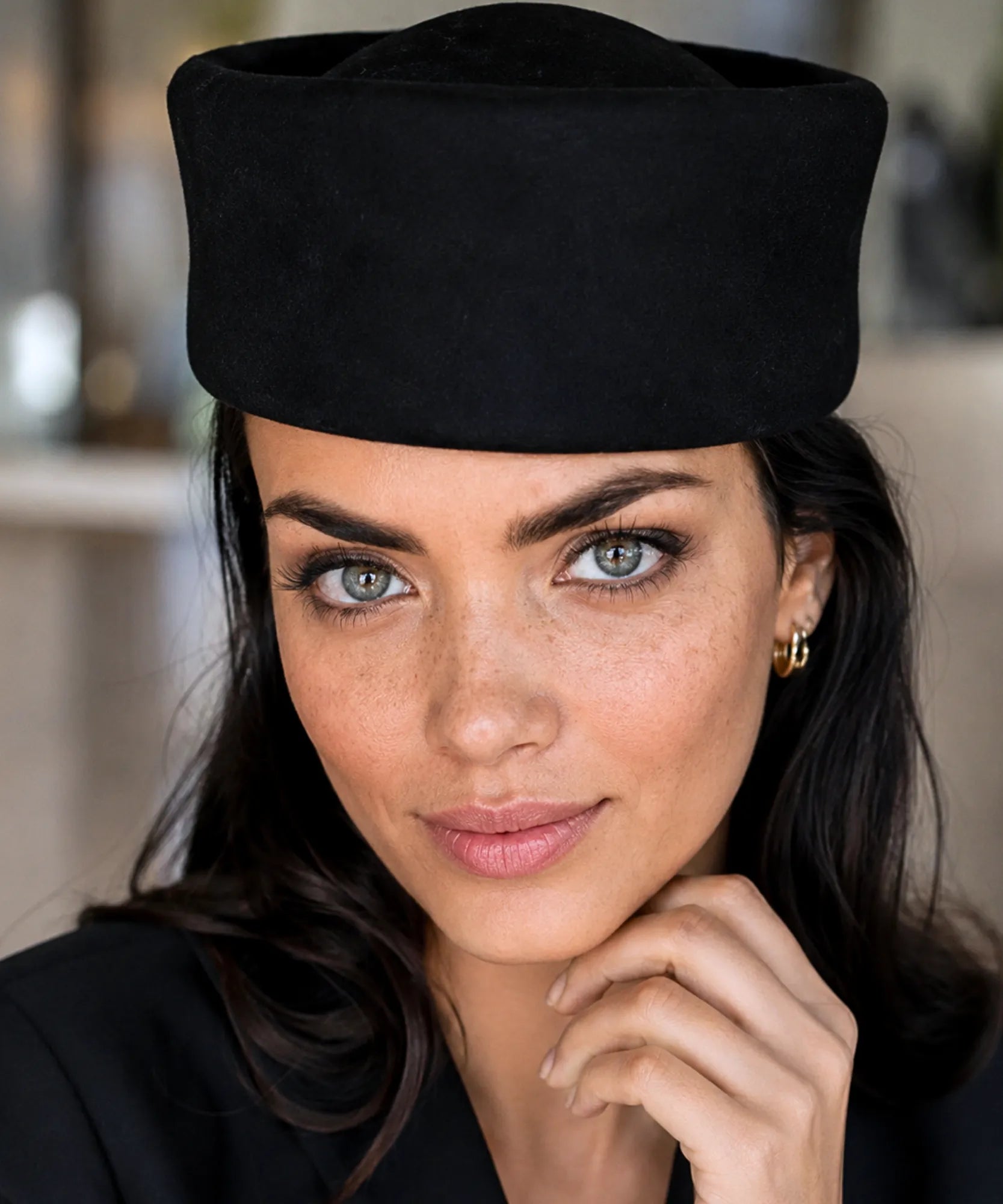Front view of the black wool pillbox hat's rounded crown
