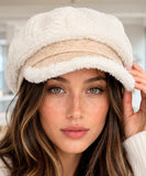 Woman wearing an ivory plush sherpa newsboy cap with a suede brim