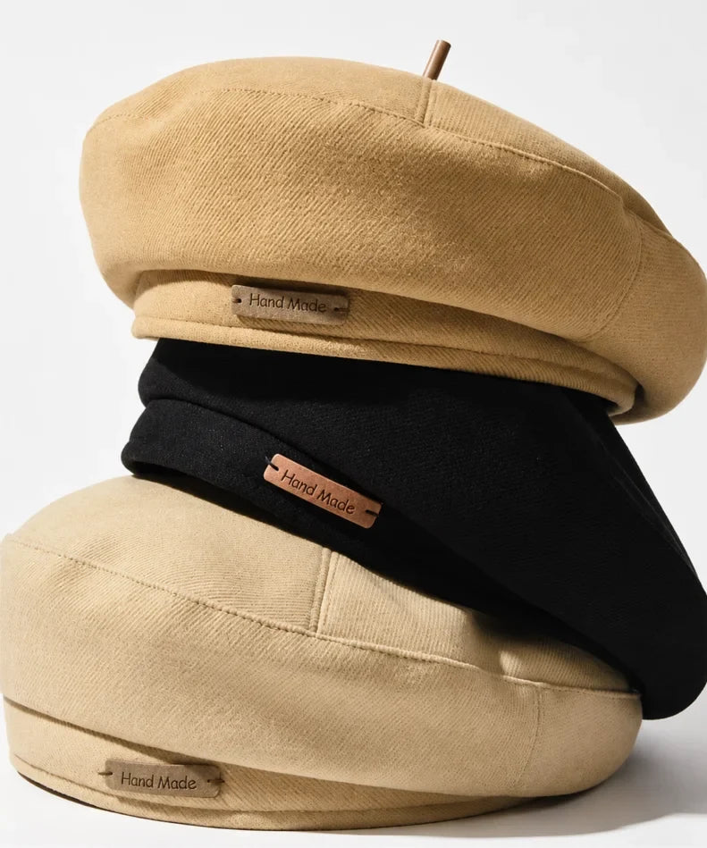 Three structured twill French berets stacked together in camel and black