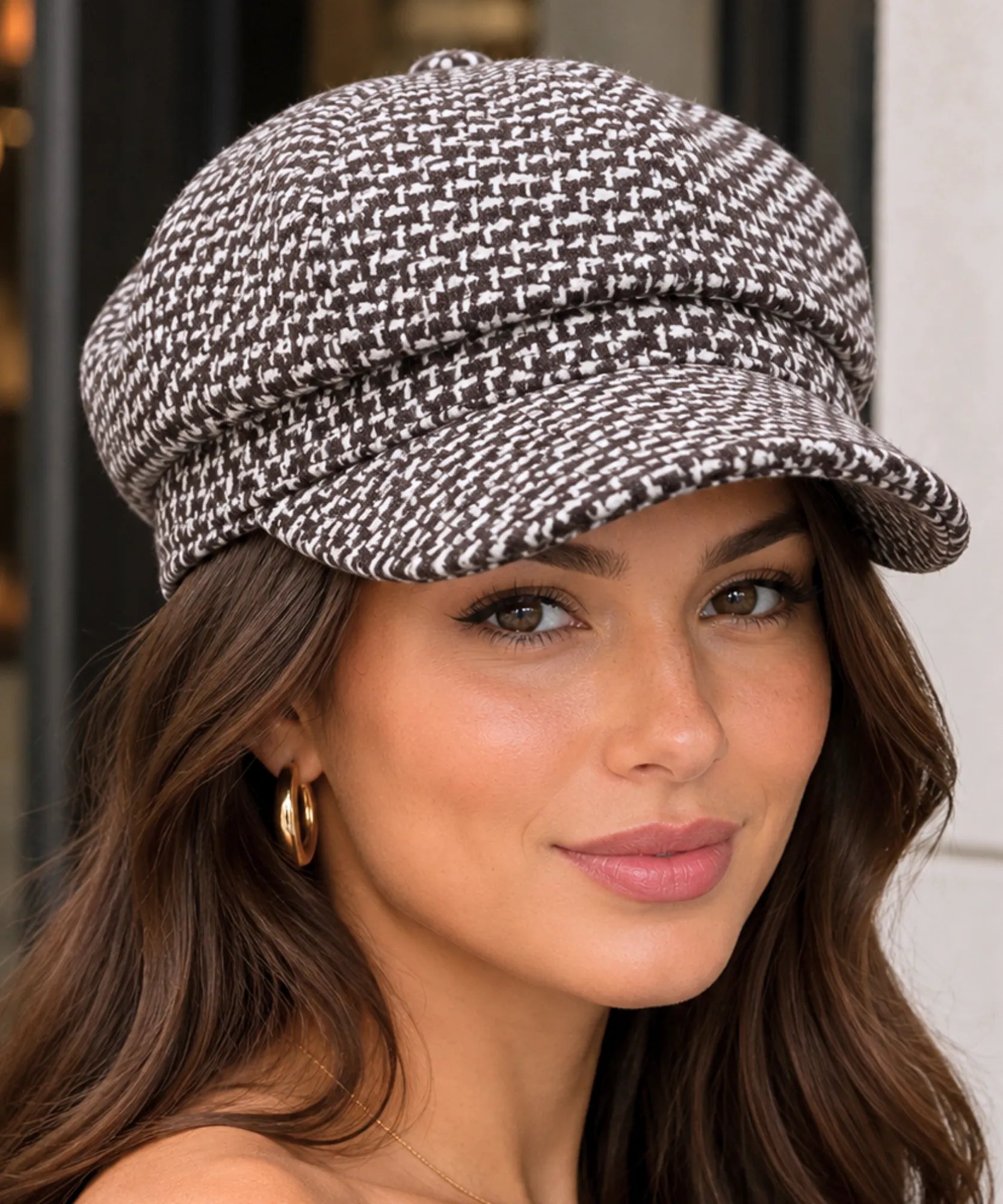 Woman wearing a brown houndstooth tweed newsboy cap