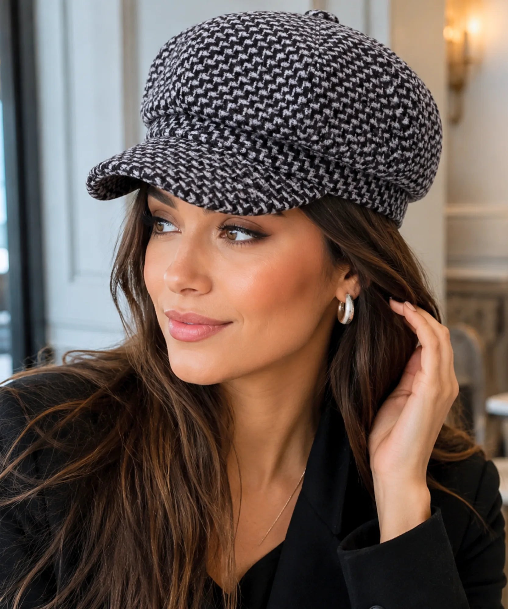 Black houndstooth tweed newsboy cap shown with its center button detail