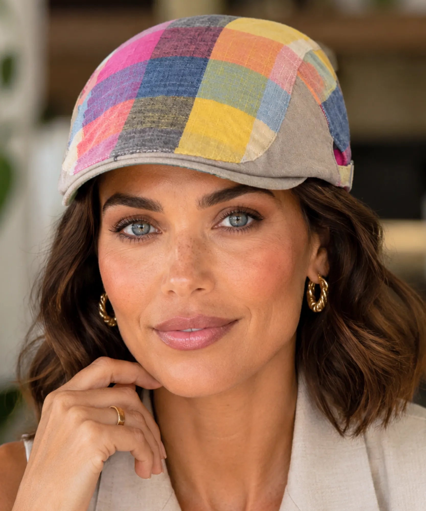 Woman wearing a multicolor patchwork plaid newsboy cap with a short structured brim