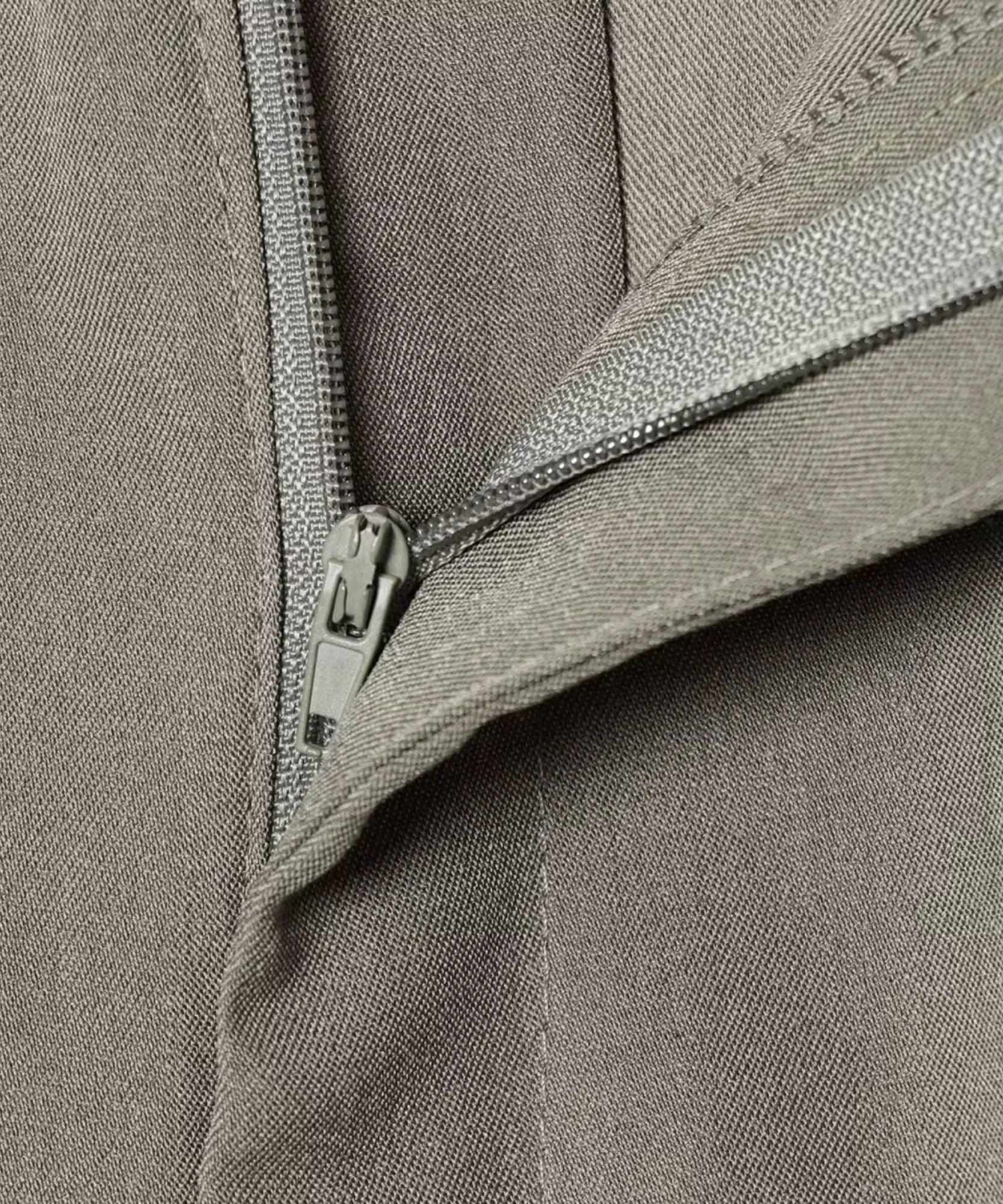 Close up of the zipper and hook closure on stone grey barrel pants