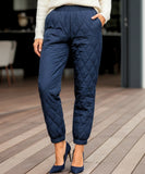 Woman wearing navy quilted joggers with diamond stitching