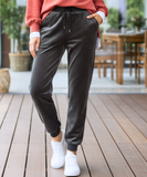 Woman wearing charcoal grey velvet joggers with a sherpa lining