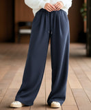 Close-up of navy fleece-lined wide-leg sweatpants showing the drawstring waist