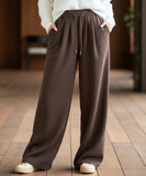 Close-up of dark brown fleece-lined wide-leg sweatpants showing the fabric texture