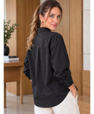 Women's relaxed black button up shirt, back view with rounded hem and ivory trousers