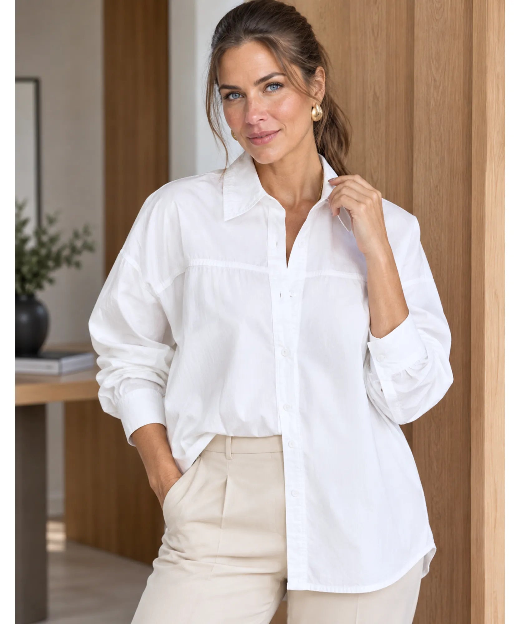 Women's long sleeve shirt in white worn with beige trousers