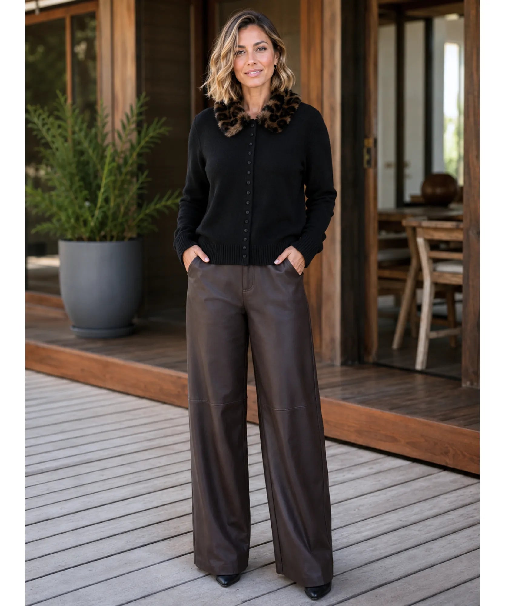 Women's black fur collar cardigan styled with wide leg trousers