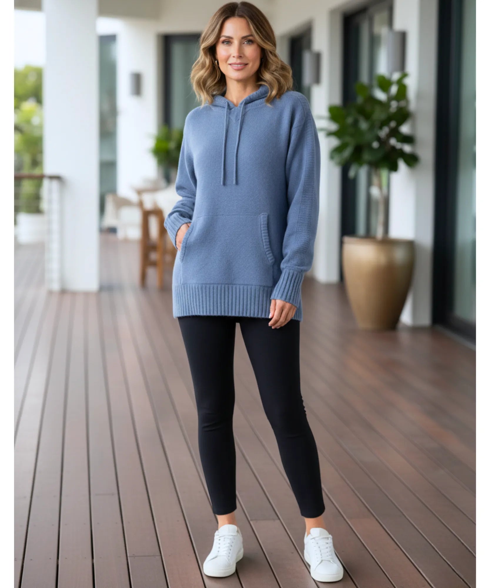 Women's dusty blue knit hooded sweater styled with black leggings